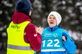 Helfer spricht mit Athletin bei Special Olympics Nationalen Winterspielen